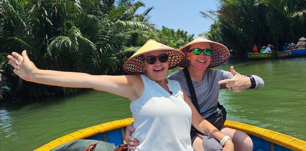 Happy tourists wearing traditional conical hats on a bamboo basket boat ride in Cam Thanh Coconut Forest during their Hoi An Private Day Tour.