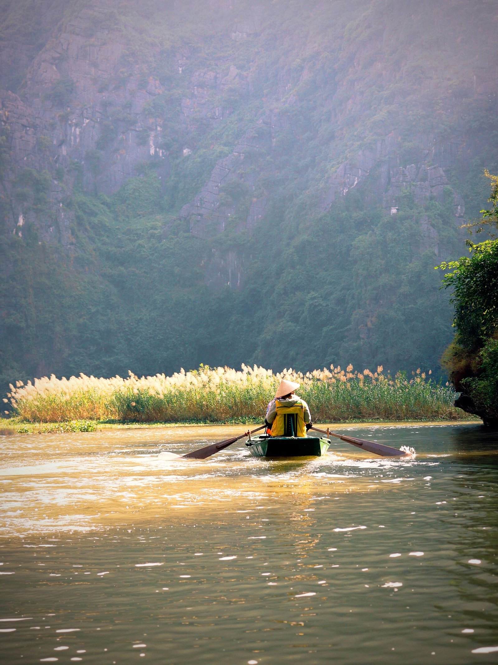 Family boat ride between limestone cliffs at Trang An, Ninh Binh